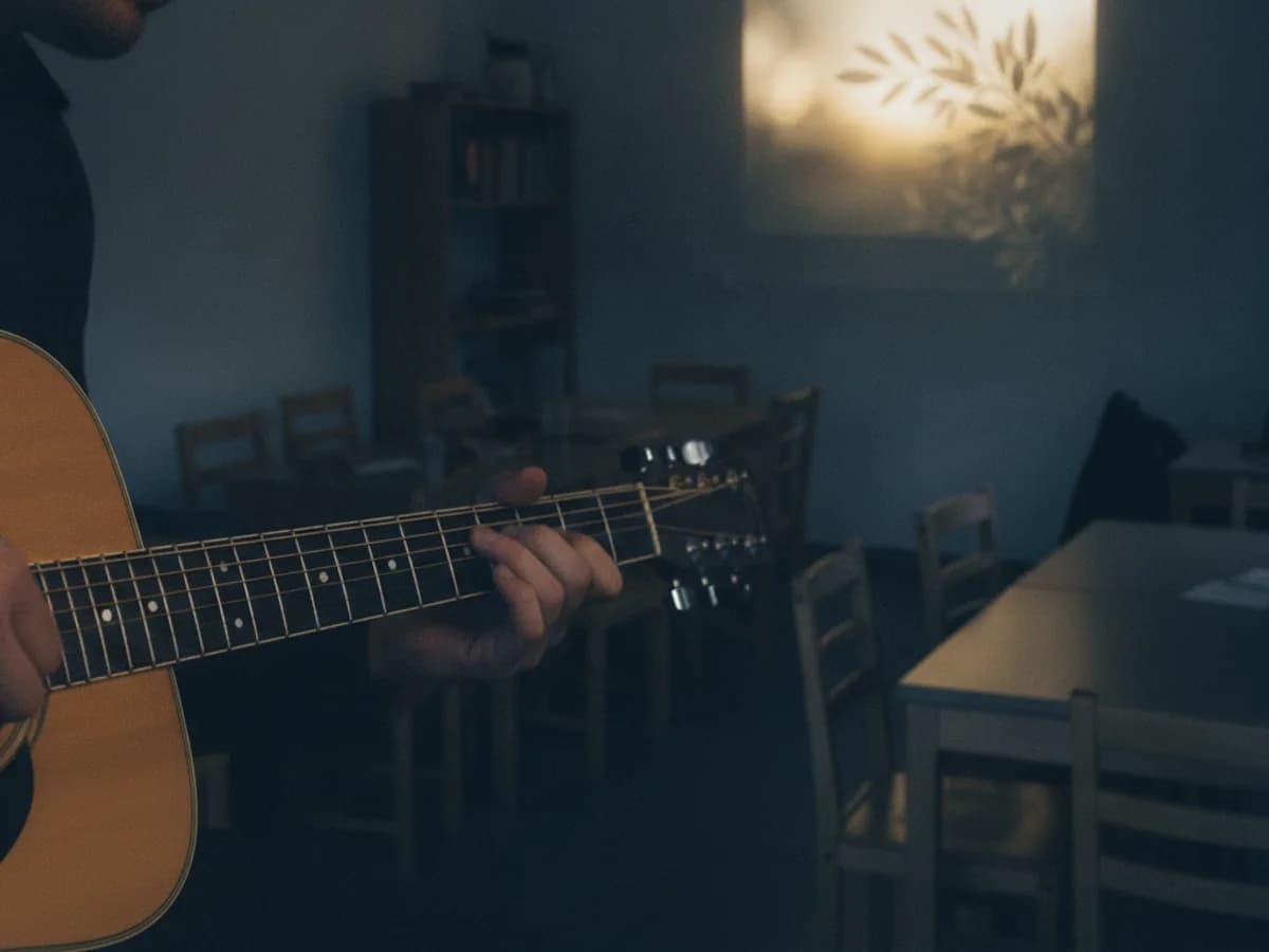 Hände spielen Akustikgitarre im warmen Bühnenlicht